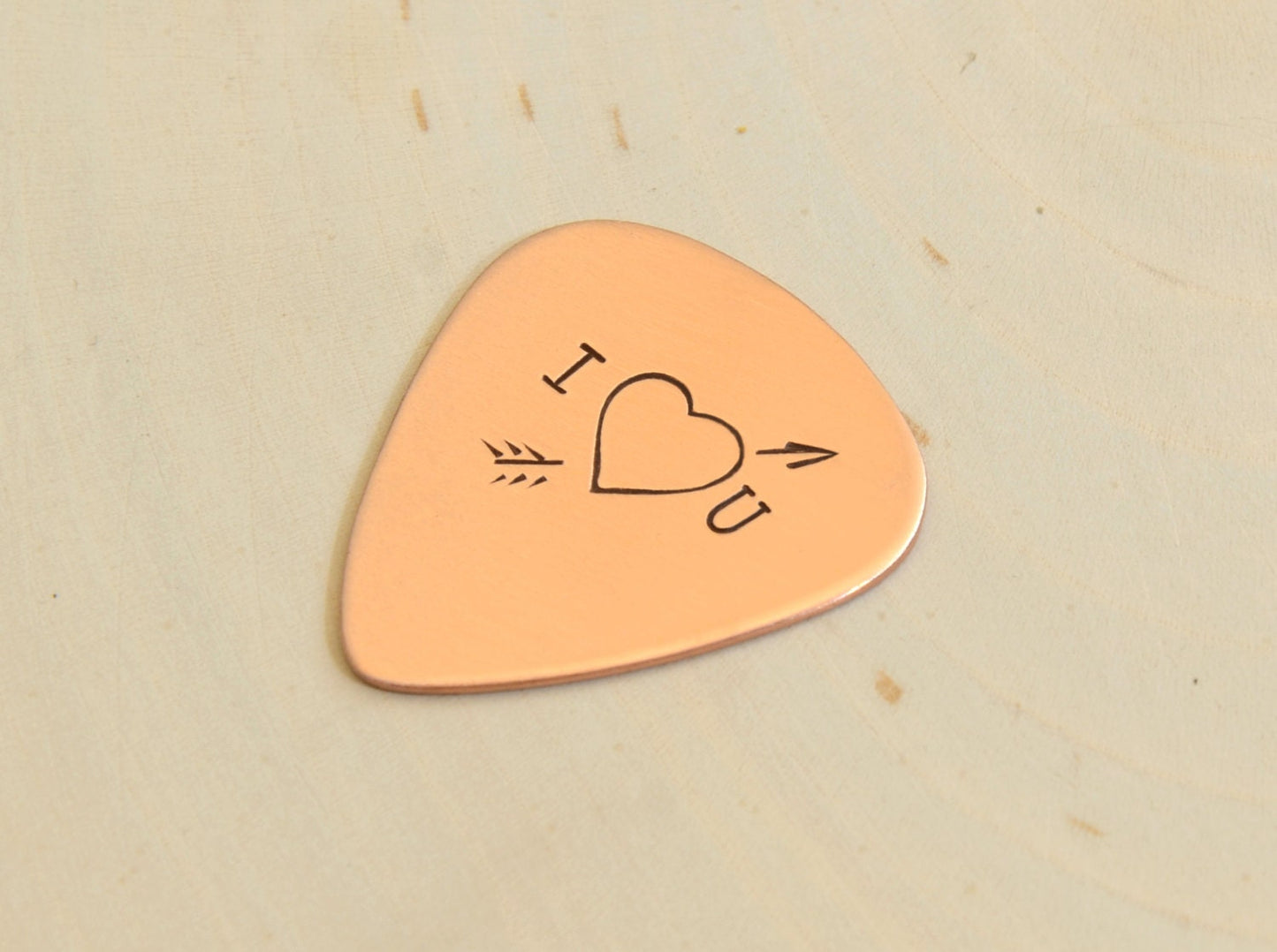 I love you copper guitar pick with Cupid's arrow of love straight through the heart
