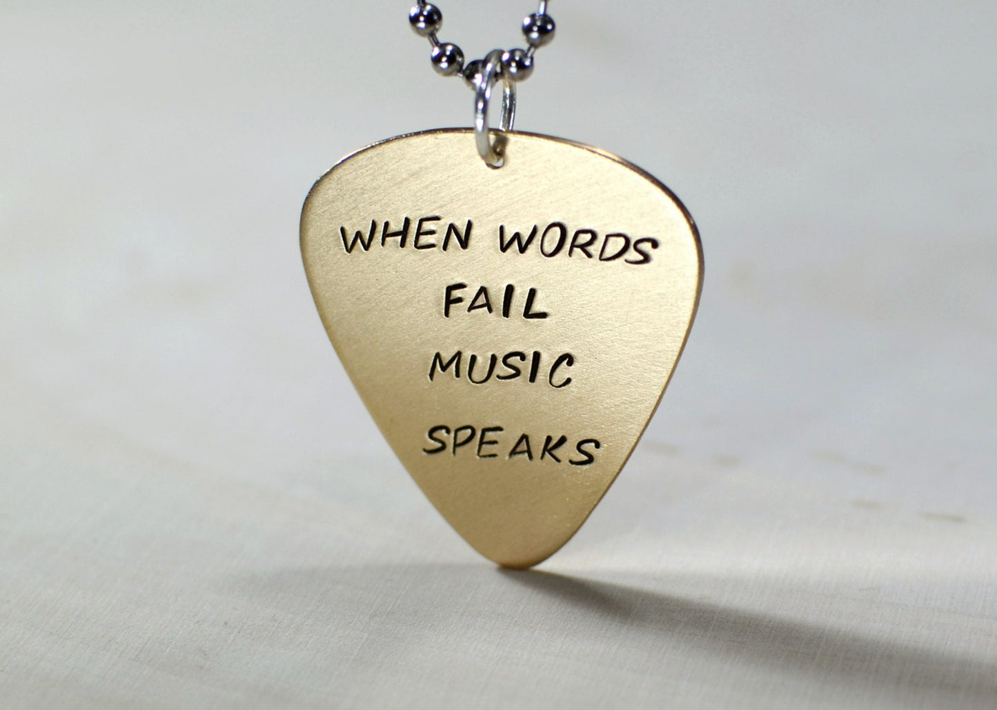 Bronze guitar pick necklace when words fail