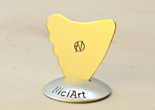 Shark Fin Brass Guitar Pick with a simple guitar theme