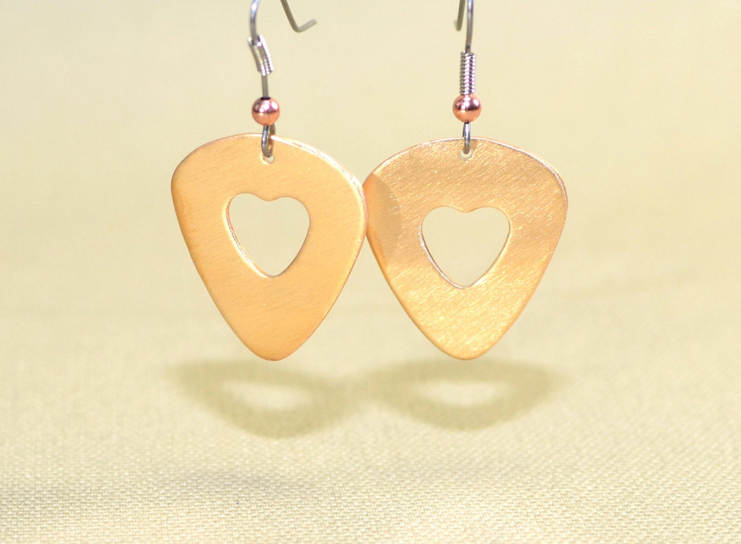 Bronze guitar pick earrings with cutout hearts