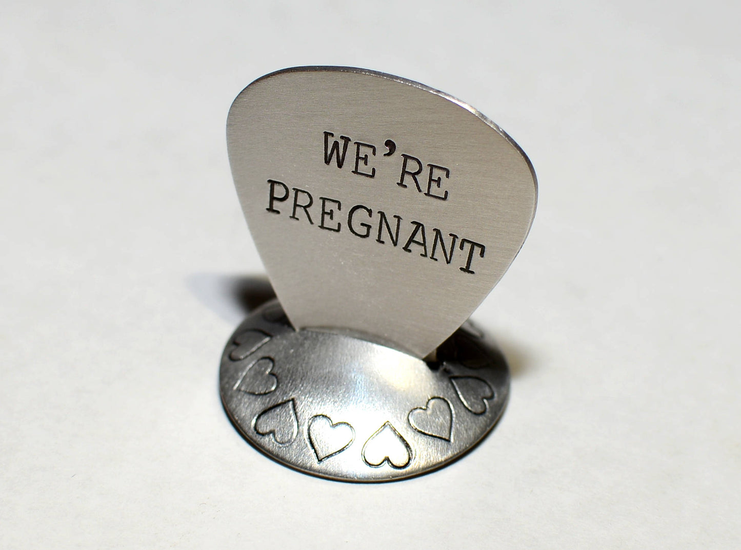 We’re Pregnant Guitar Pick for a Rocking Surprise in your choice of metals