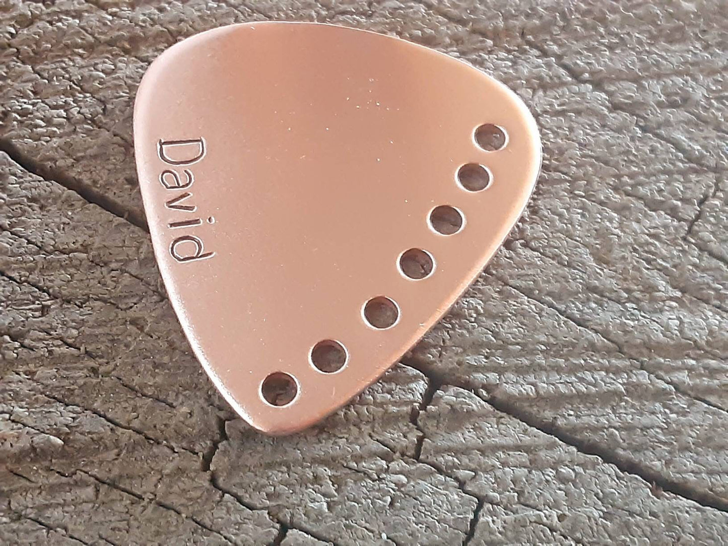 Custom copper guitar pick with holes along the edge and your name