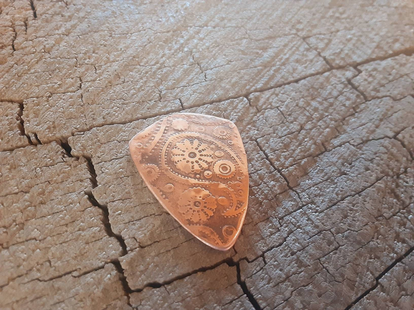 Guitar pick with paisley pattern in copper