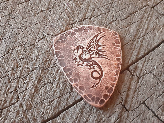 Shield style guitar pick in copper with a dragon design