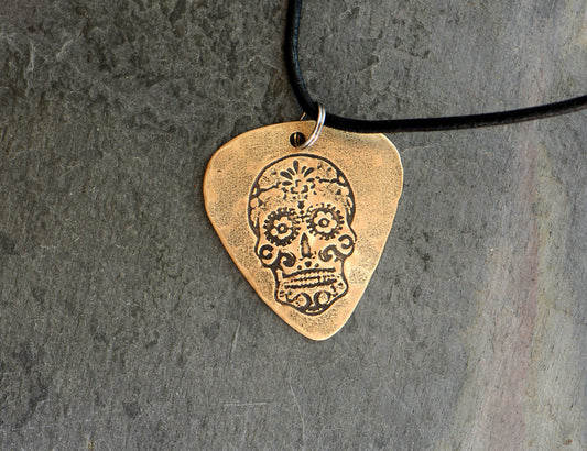 Bronze guitar pick with sugar skull necklace