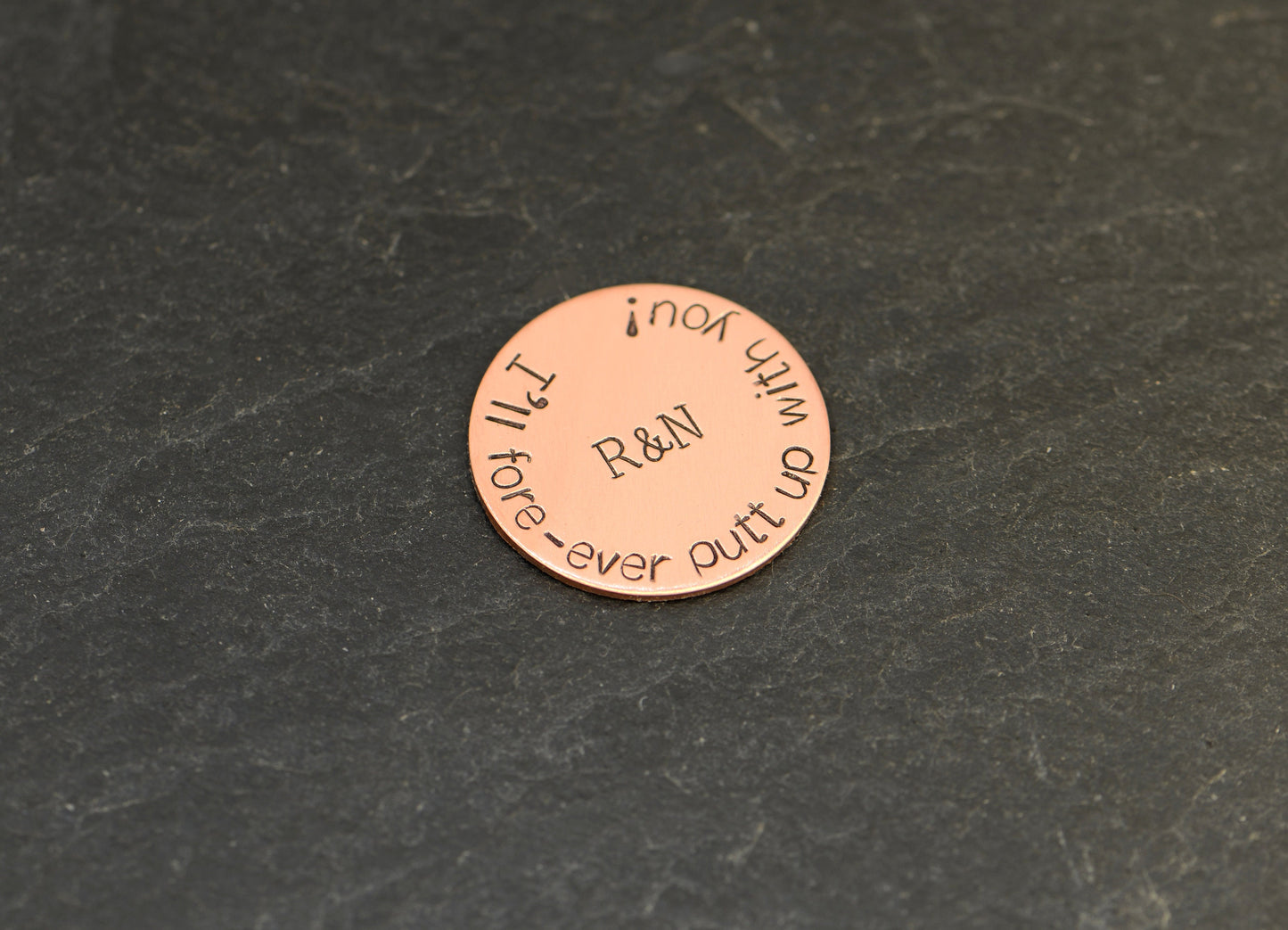 Initials on copper golf ball marker