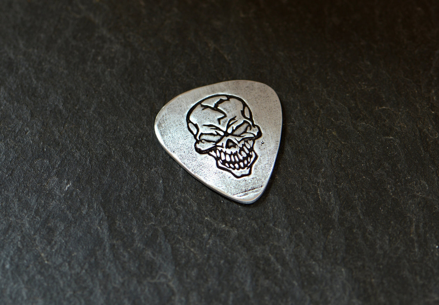 Sterling silver guitar pick with skull design